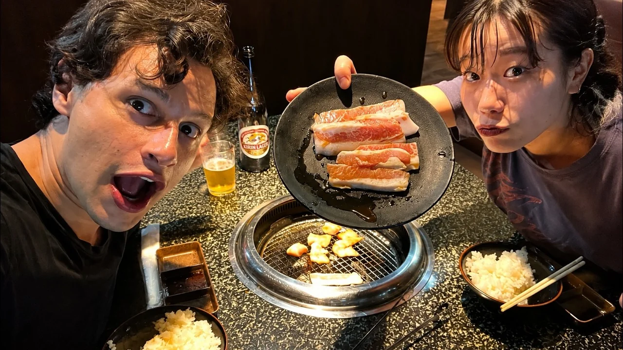 Bruno e Hiyori em um restaurante de yakiniku, com carnes sobre a churrasqueira